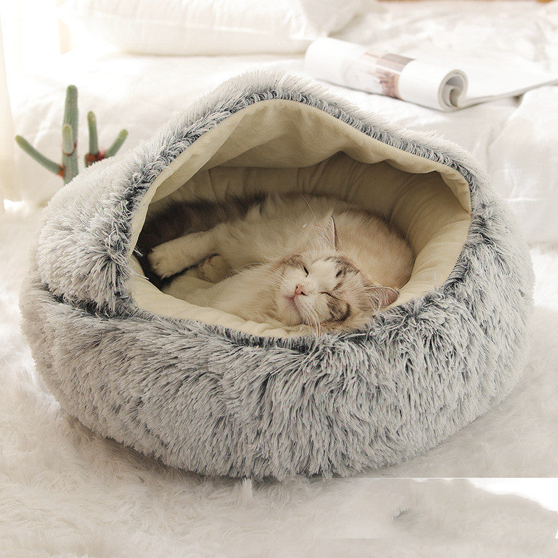 Cat sleeping in a round plush pet bed from Pet La'Fleur, providing warmth and comfort for winter.